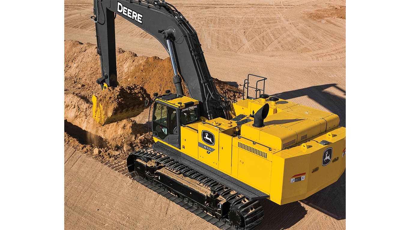 A bird's-eye view of an 870P-Tier Excavator scooping dirt at a worksite.
