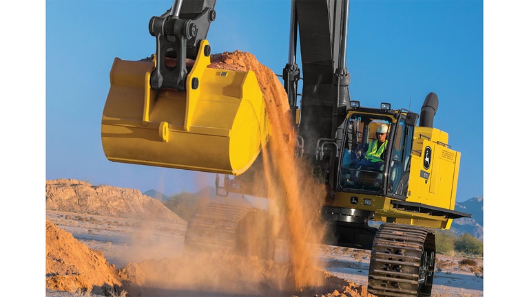 An operator using an 870P-Tier Excavator to scoop dirt at a worksite.