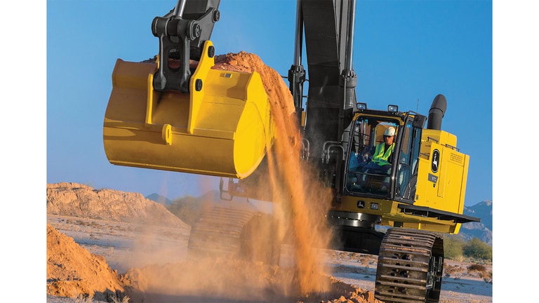 Un opérateur qui utilise une excavatrice 870P-Tier pour ramasser de la terre sur un chantier.