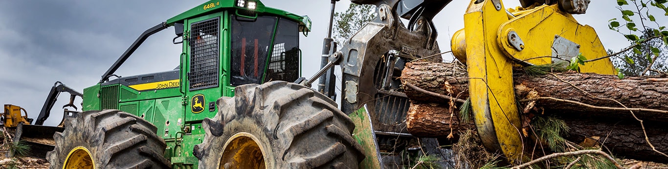 A John Deere 648L-II Skidder hauls logs through the forest