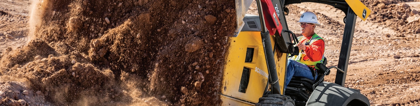 Tracteur avec chargeur en marche arrière sur un chantier de construction