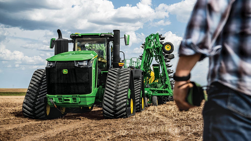 Tracteur 9RX 830 dans un champ avec le semoir pneumatique replié