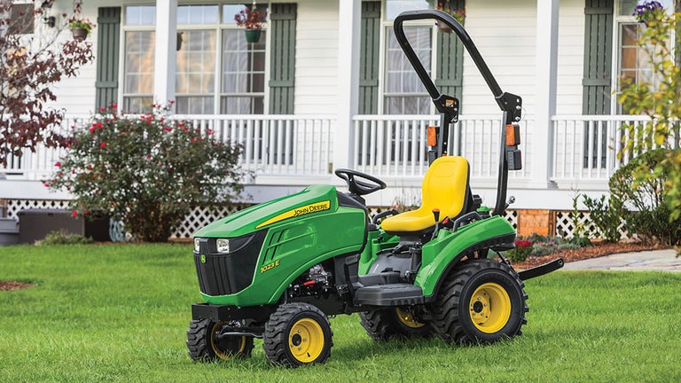 Tracteur compact 1023E sur la pelouse devant la maison