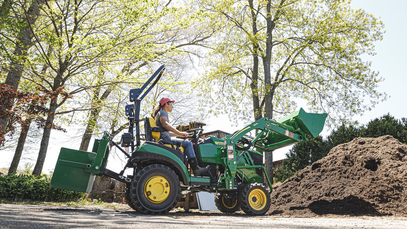 Une personne qui conduit un tracteur compact 1025R 