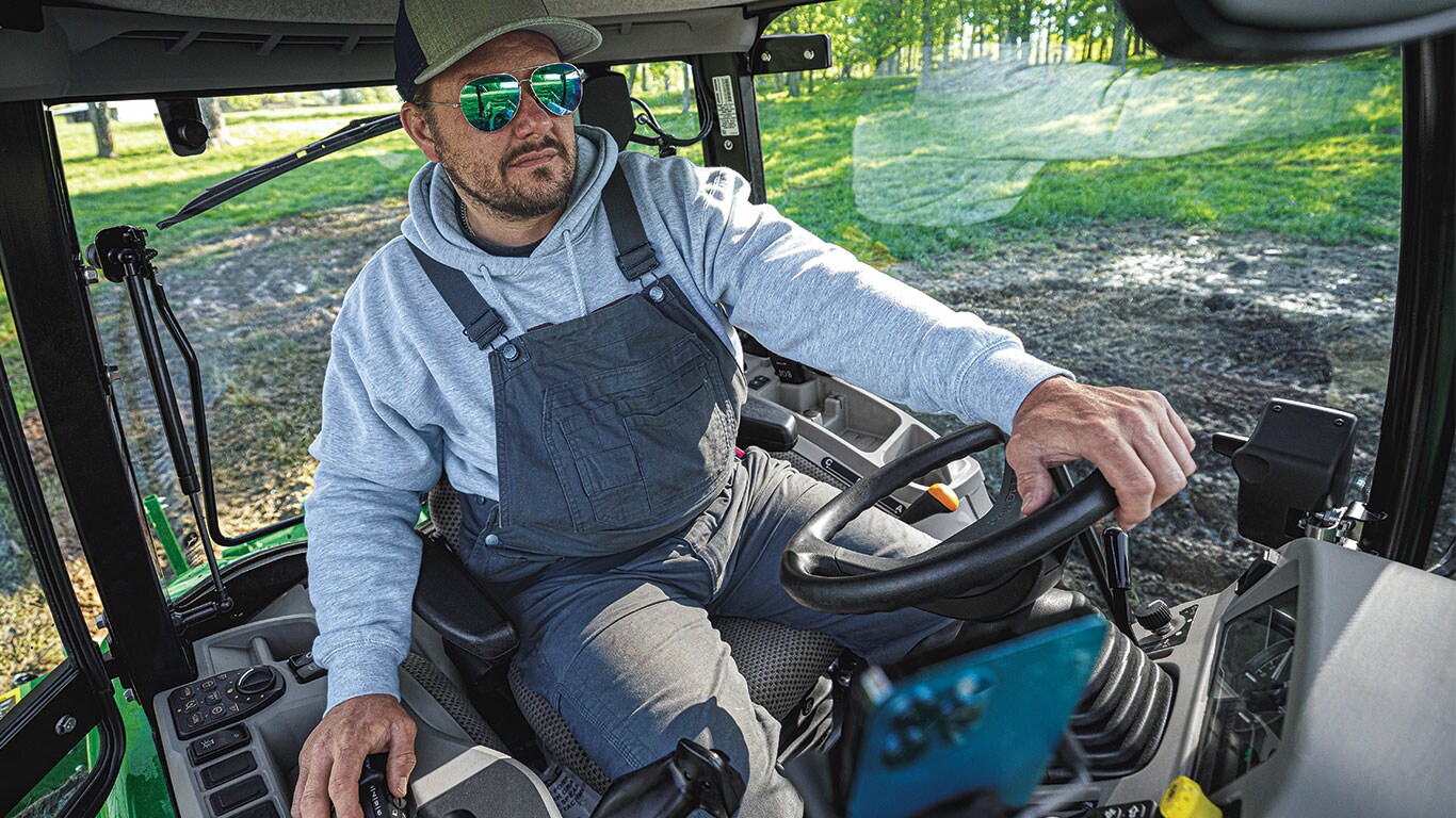 Personne aux commandes dans la cabine d'un tracteur en automne