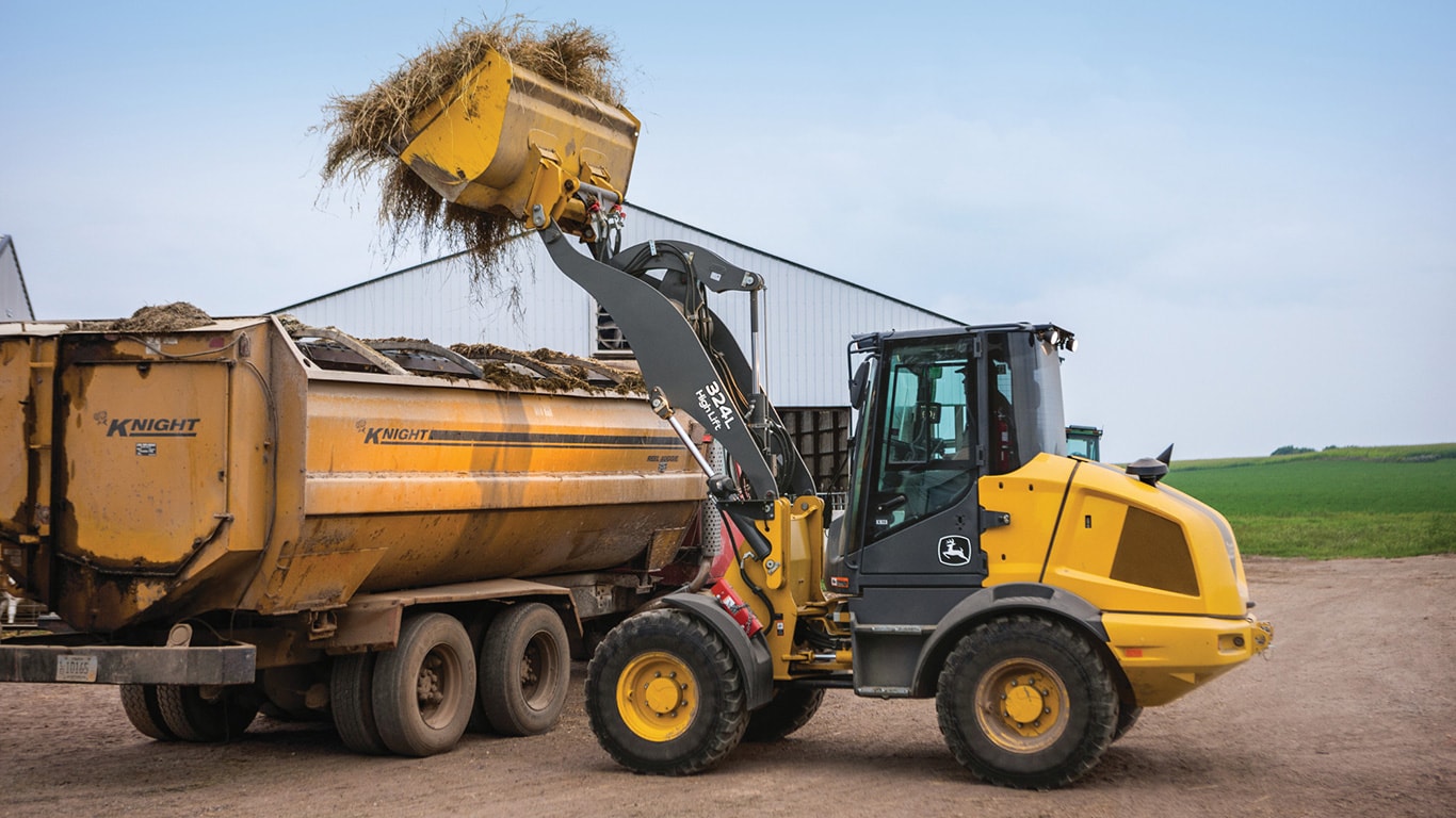 324L John Deere Compact Wheel Loader unloading hay using the high-lift option