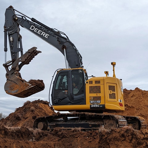 Excavatrice 245G LC creusant sur un chantier.
