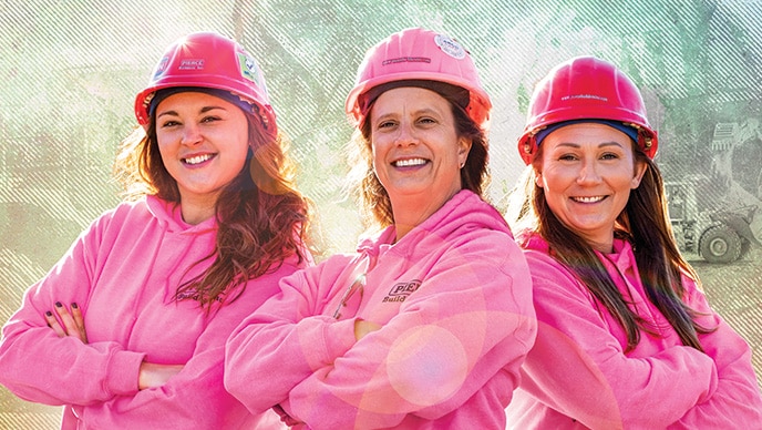 Missy Madden, Alescia Pierce et Erin McFague se tiennent debout et portent des chandails en molleton et des casques roses.