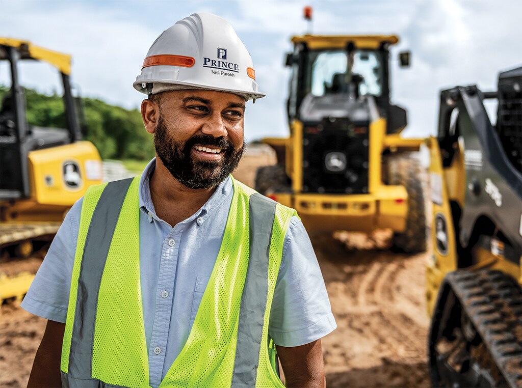 Neil is smiling as he is walking at a road widening project in Florida.