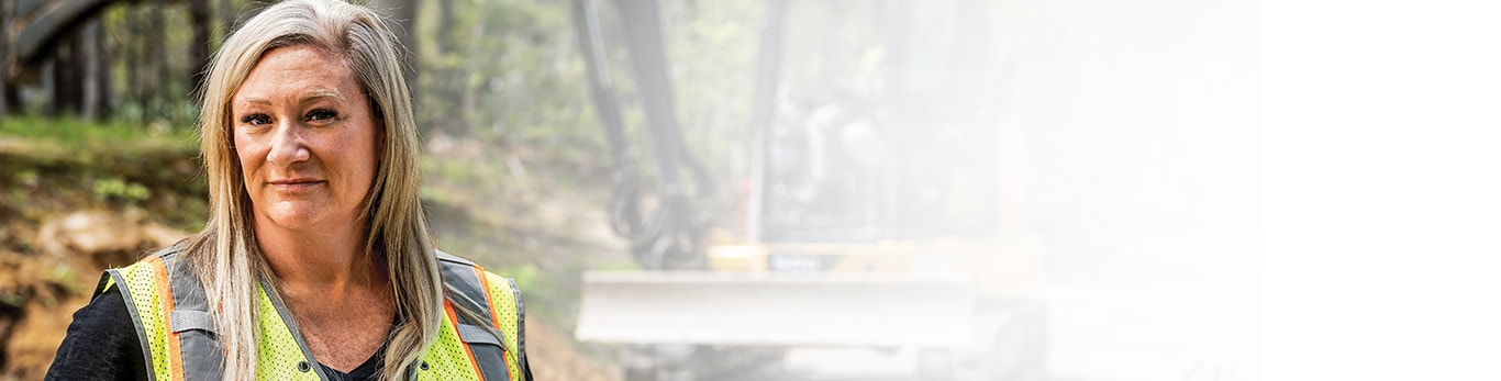 Jennifer Morris devant une excavatrice compacte 50G de John Deere.