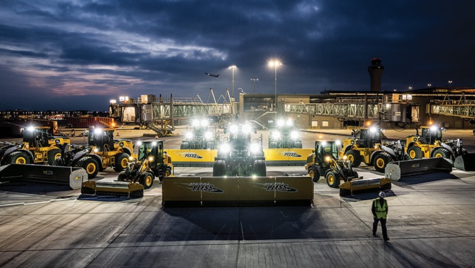 Aaron Kaden, Fleet Asset Superintendent, walks past a fleet of John Deere Wheel Loaders at Kansas City International Airport.