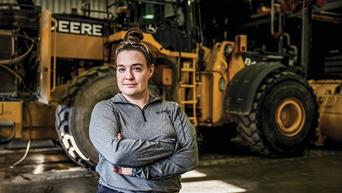 Michelle Roth with Murphy Equipment stands in front of a wheel loader