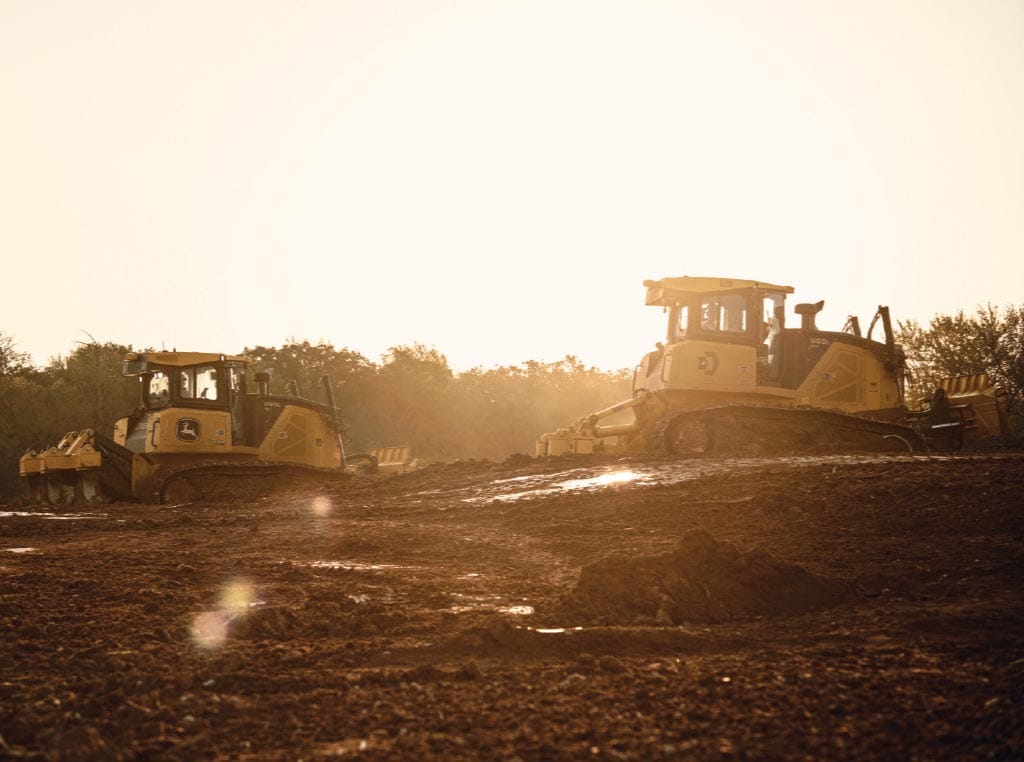 Side by side, a pair of 850L Dozers use their rippers to churn the ground at the site.