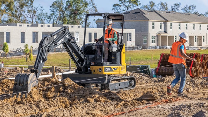 Le godet d'une excavatrice compacte 26P s'étend pour commencer à creuser dans le sol