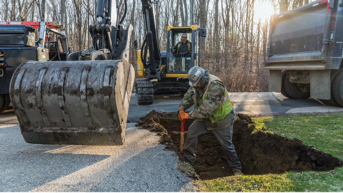 Michael Flaherty opère une excavatrice 85G de John Deere pendant que Jacob Pepin prépare le trou pour le caisson d’étançonnement.