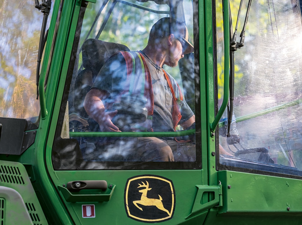 Eli Larson regarde par la fenêtre de la cabine de son porteur 1210G.