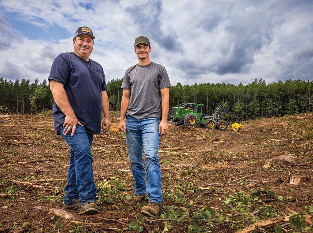 Kevin and Nick pose with a 768L-II Bogie Skidder in the background.