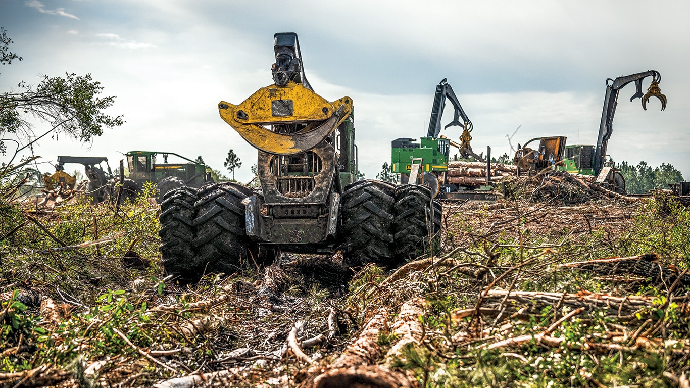 De gauche à droite. Des débardeuses à pince 848L-II et 948L-II de John Deere avec deux chargeuses à griffe 437E travaillent ensemble sur la jetée.