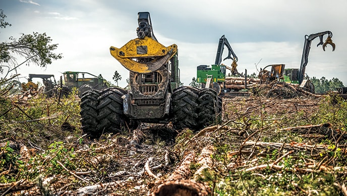 From left to right. A John Deere 848L-II, 948L-II Grapple Skidders with two 437E Knuckleboom Loaders work together at the landing.