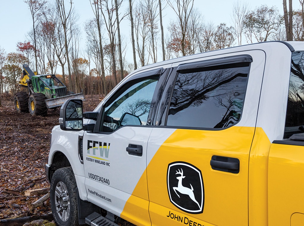 Camion de service de Foster F Wineland à l’avant-plan et débardeuse 848H à l’arrière-plan.