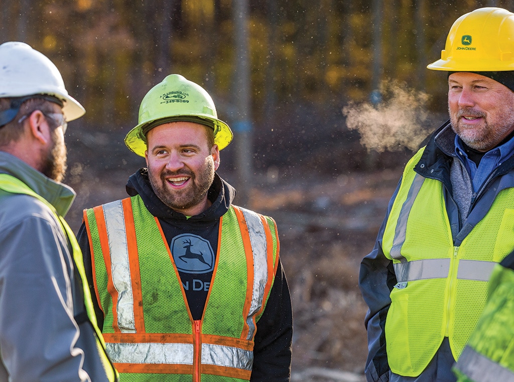 Andrew, Ron et Dale discutent de la remise à neuf de la débardeuse sur le site de débarquement.