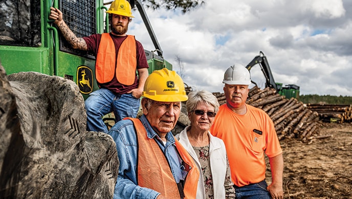 Scott Decker, Vernon Decker père, Barbara Decker et Vernon Ray Decker se tiennent près d’une débardeuse à câble 748L-II.