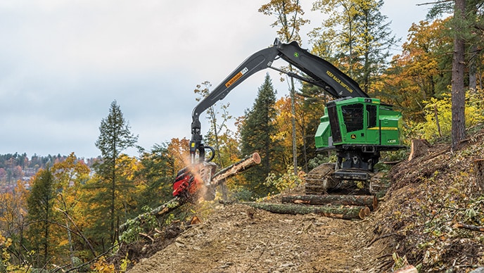 Une abatteuse-façonneuse chenillée 859MH de John Deere équipée d’une tête d’abatteuse-façonneuse HTH623C de Waratah transforme des rondins de bois dur dans une forêt en pente abrupte de la Pennsylvanie.