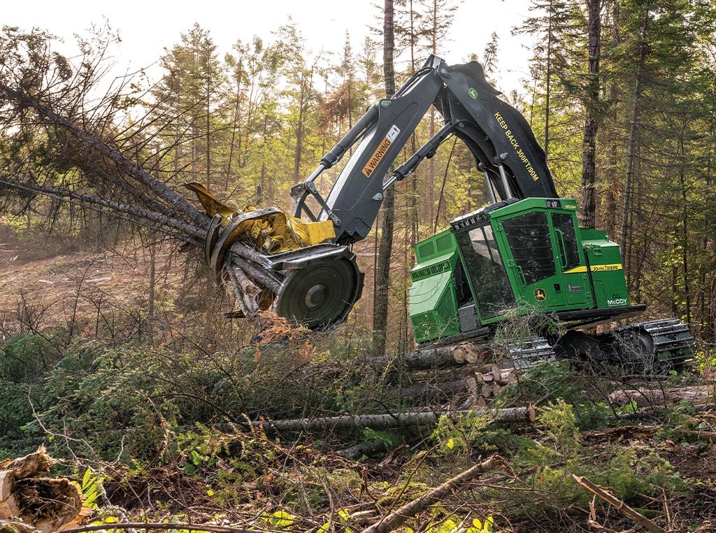 Une abatteuse-groupeuse chenillée 853M déplace simplement des arbres coupés dans la pince d'une tête d'abattage FR22B.