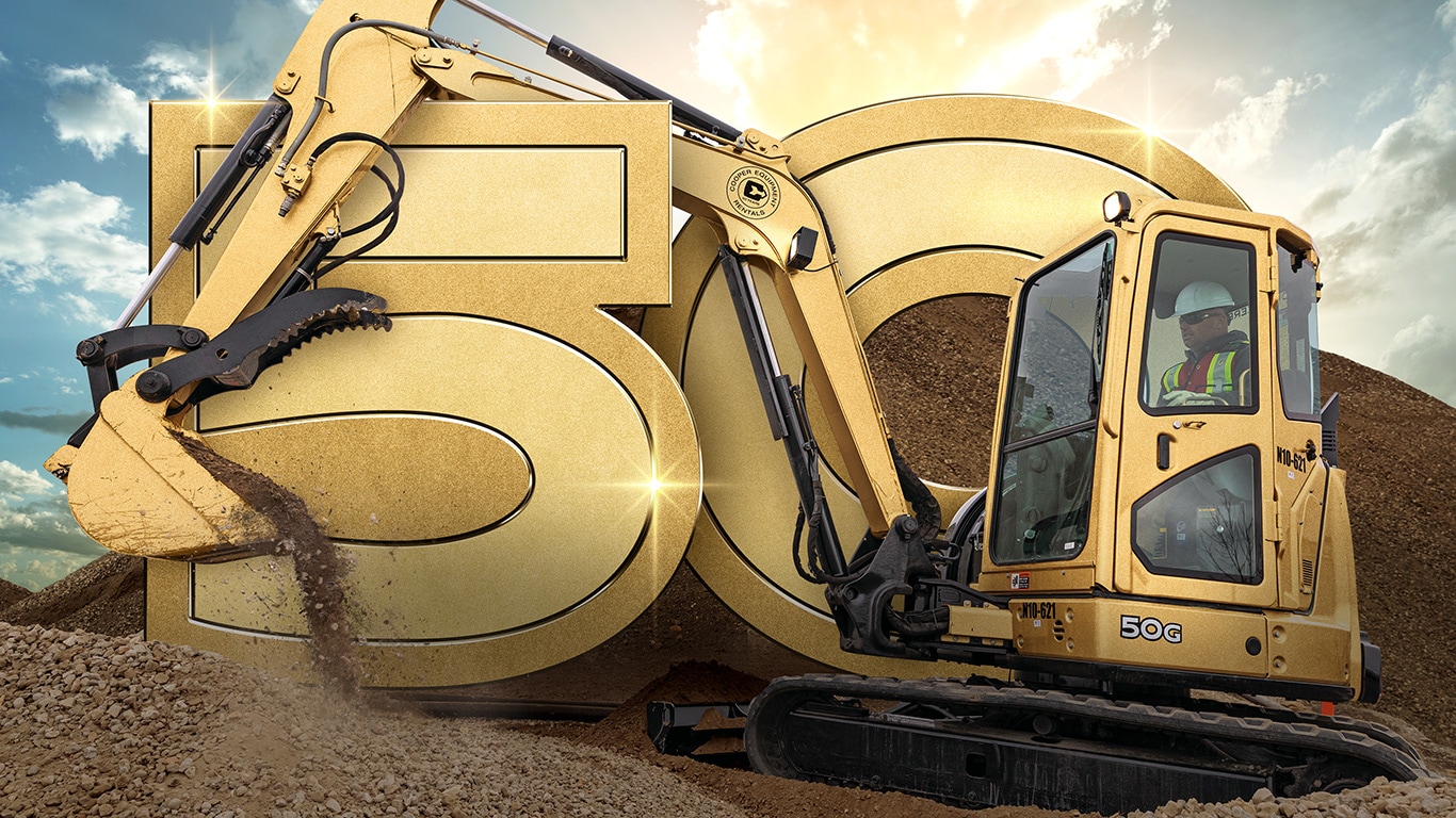 Une excavatrice compacte 50G de John Deere spécialement peinte en or excave de la terre sur un chantier canadien.