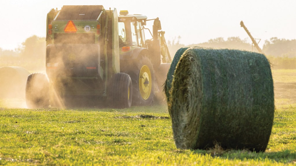 Tracteur tirant une rotopresse et rotopresse à l'arrière-plan