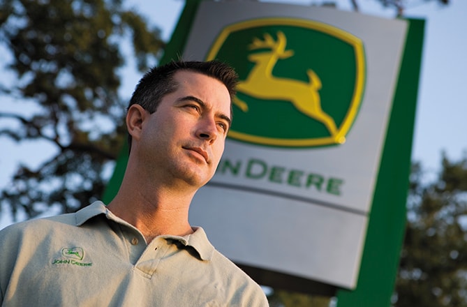 Concessionnaire devant une enseigne John Deere