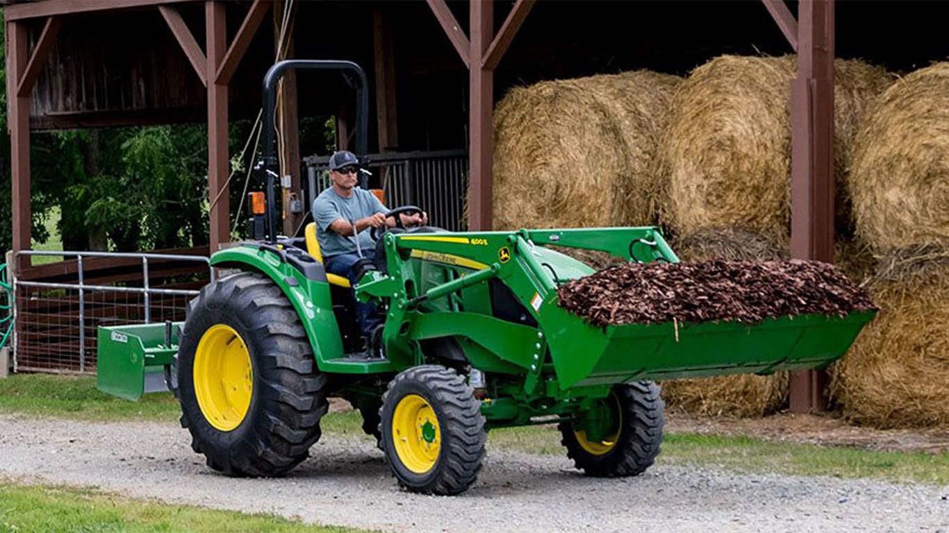 Man driving 4044m tractor carrying leaves