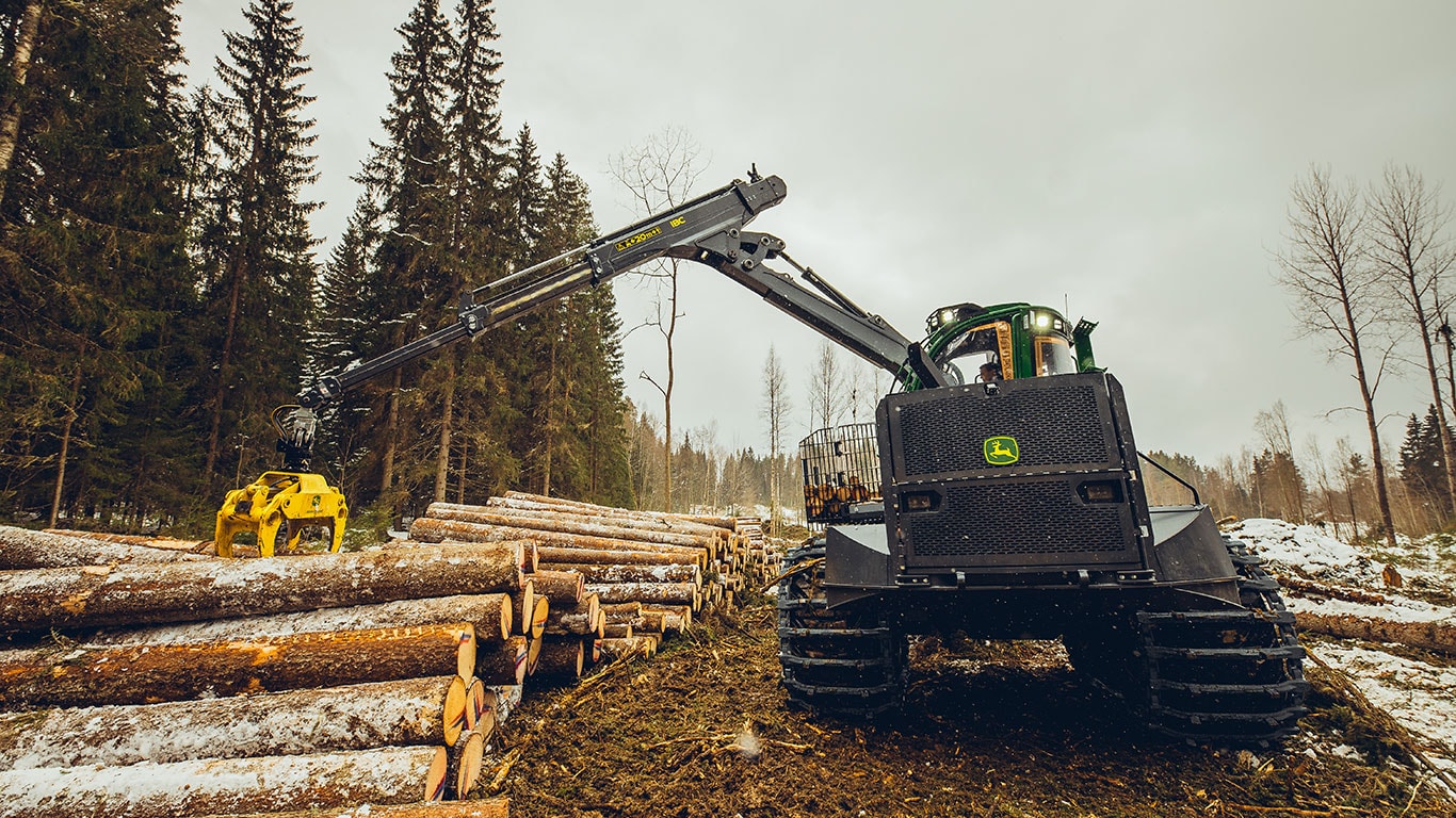 Porteur 2510H de John Deere avec flèche étendue dans une zone d’exploitation forestière.