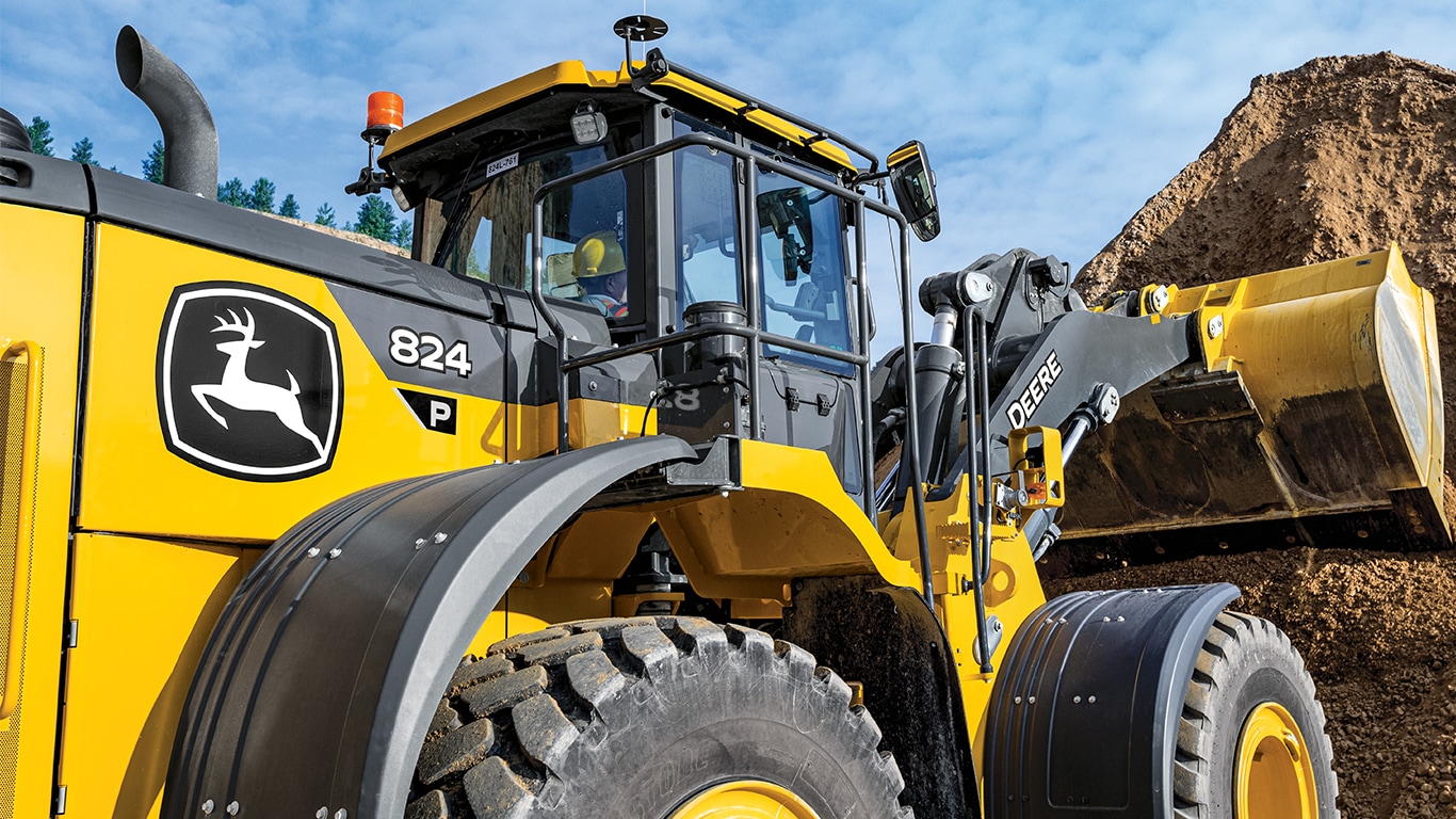 La chargeuse à roues 824 de catégorie P-tier de John Deere ramassant de la terre d’une pile