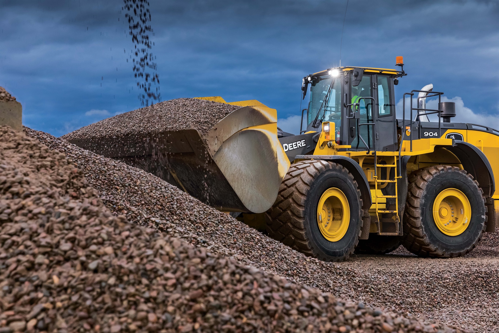 La chargeuse à roues 904 de catégorie P-tier de John Deere ramassant du gravier d’une pile sur le chantier