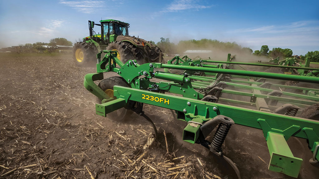 Vue latérale du cultivateur agricole à attelage flottant 2230FH tracté dans le champ à midi.