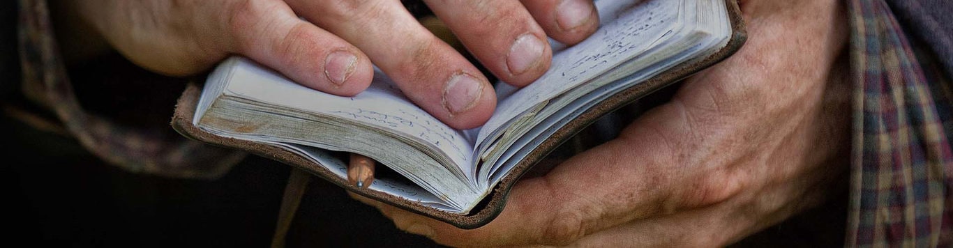 Close up on dirty hands holding notebook