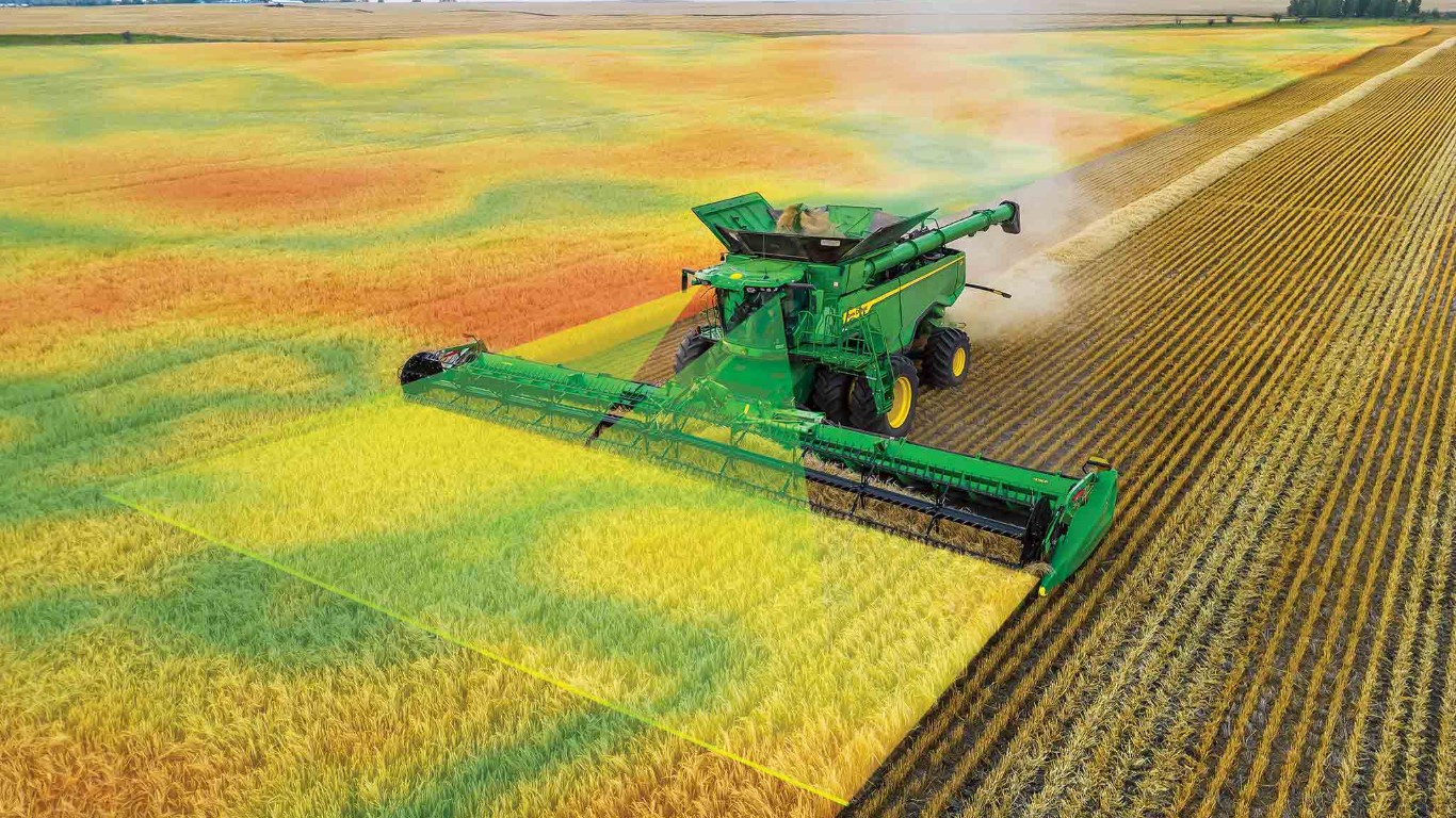 X9 Combine harvesting a field with various colors overlaid to show where there are crop changes.