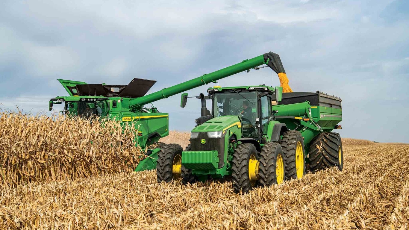 Combine in field pouring grain into a grain cart.