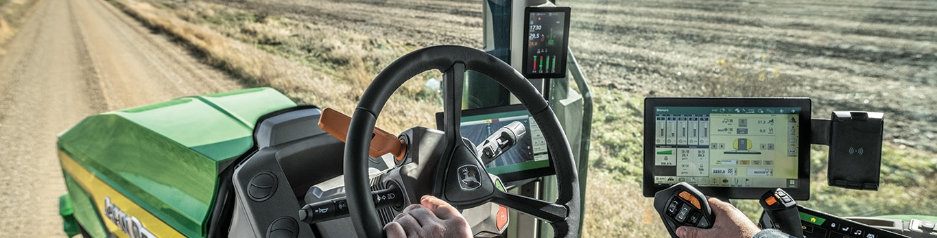 Vue intérieure du tracteur&nbsp;8R avec la route au premier plan.