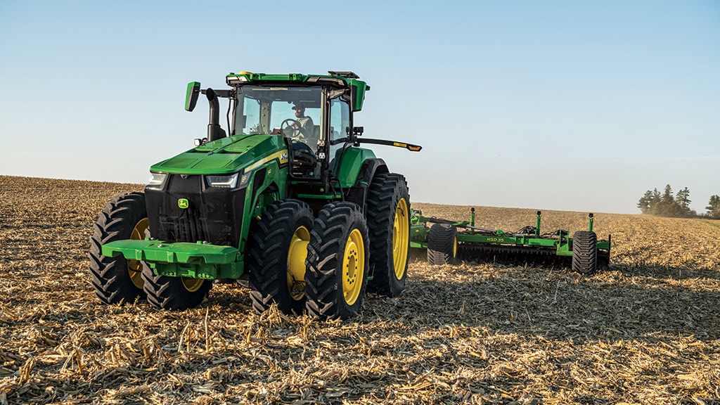 Tracteur&nbsp;8R tirant un outil de labourage.