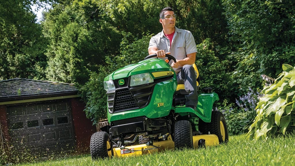 Man mowing grass with an X330 lawn tractor
