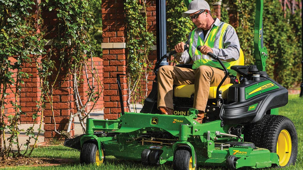 Man mowing grass beside brick columns with a Z930R ZTrak zero-turn mower.
