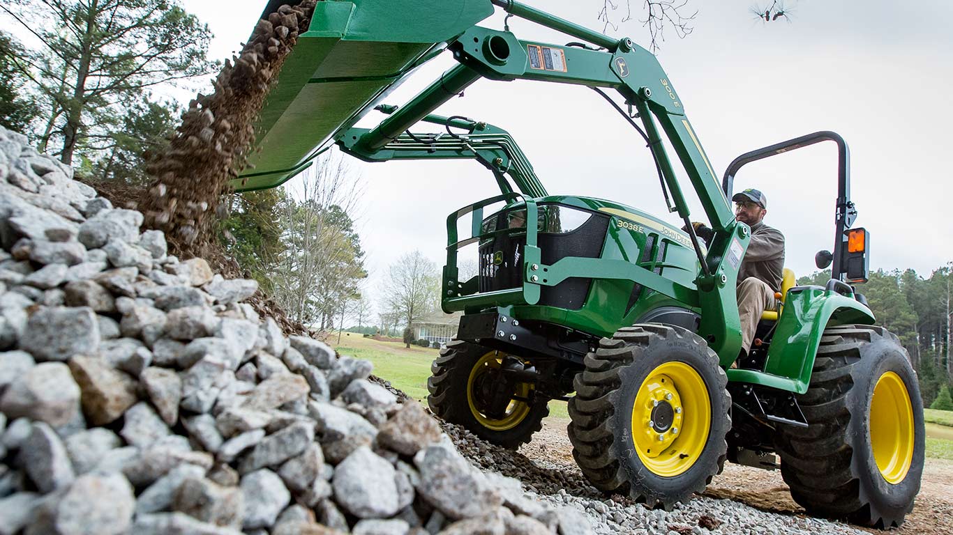 3e tractor using front loader to dump large pile of rocks