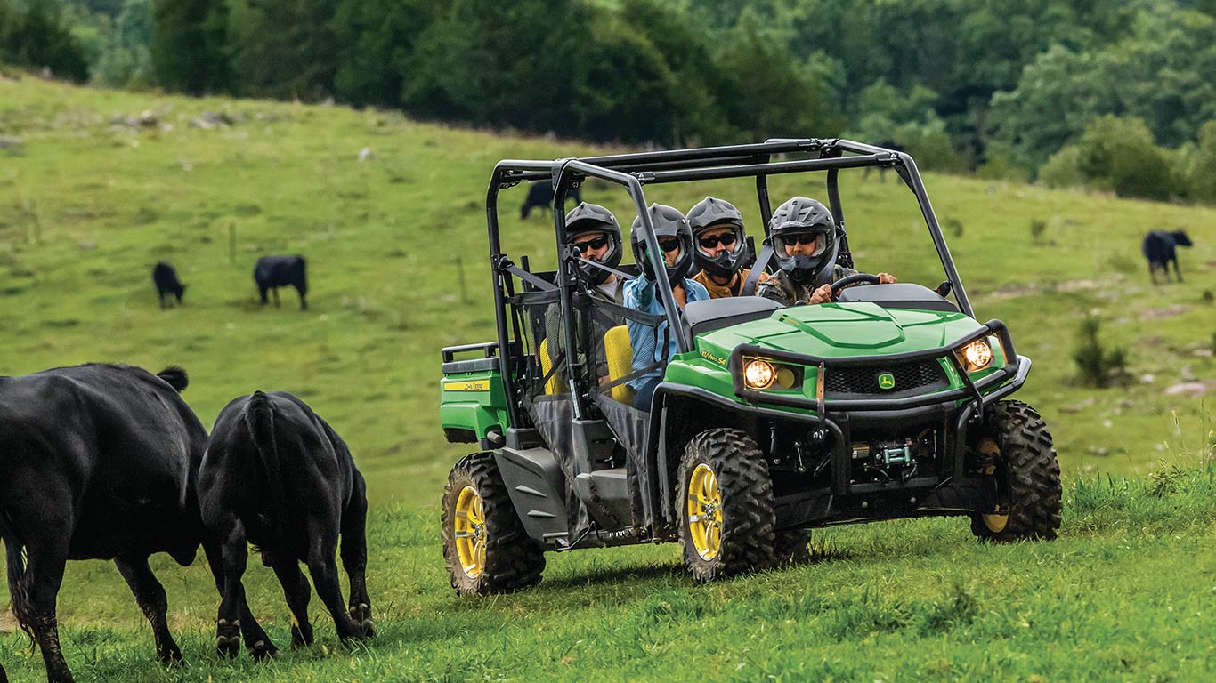 XUV560e with 4 passengers in a field with cows