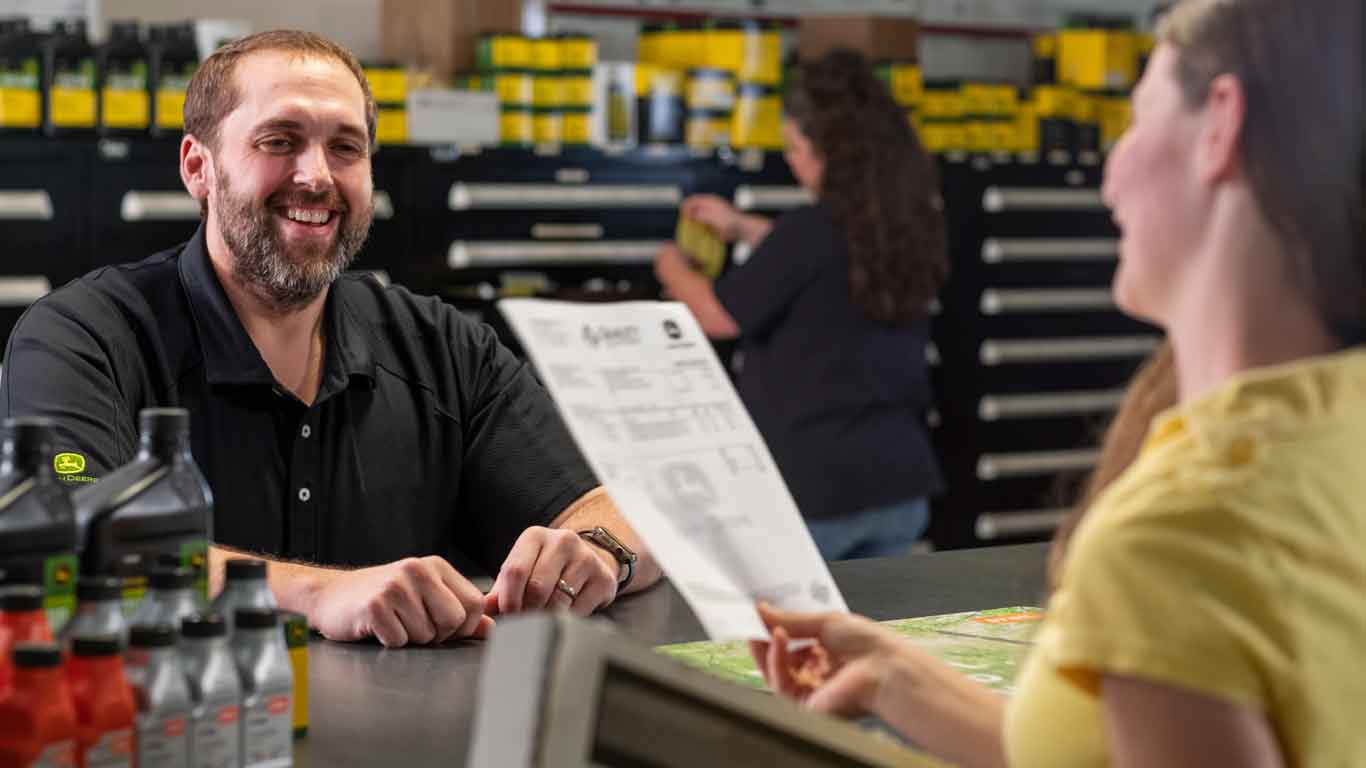 Woman sitting with a dealer in a dealership going over her statement