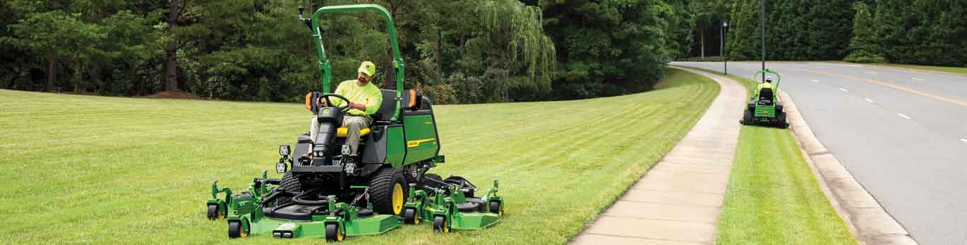 Deux hommes au volant de tondeuses commerciales de John Deere