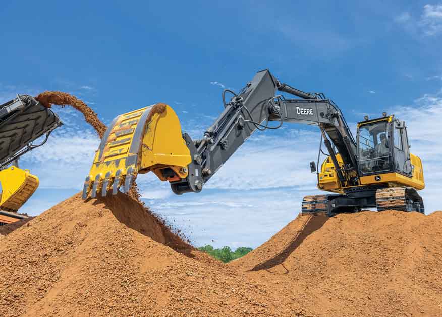 Équipement de construction John Deere sur un chantier avec de la terre qui tombe du godet