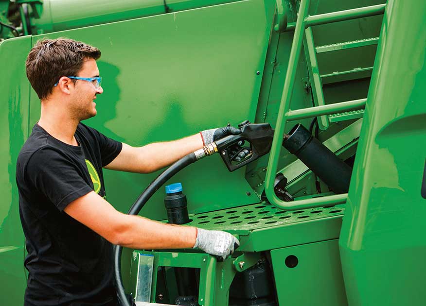 Man filling up gas on ag equipment