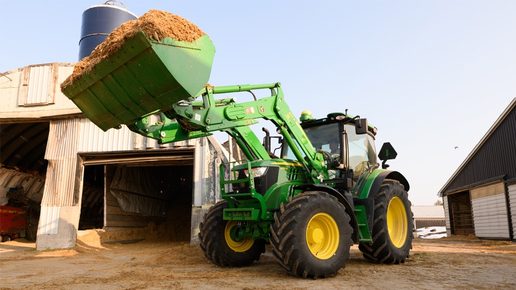 large tractor with front loader hauling dirt